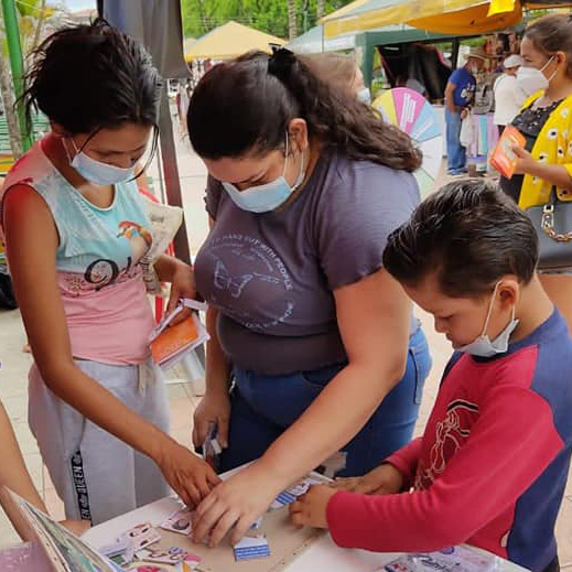 Mujeres y niños aprendiendo con arte de papel - Acceso a lugares seguros para mujeres
